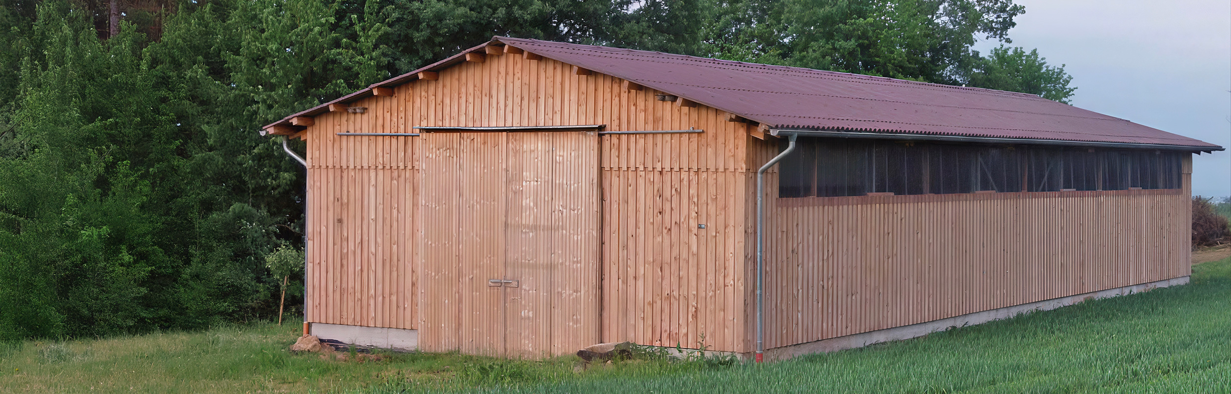 Vielzweckhalle mit Holzverschalung auf einem landwirtschaftlichen Hof