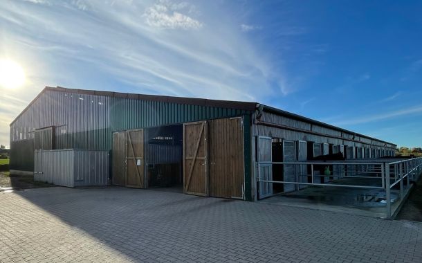 ußenansicht einer modernen landwirtschaftlichen Stallhalle in Holz- und Metallbauweise.