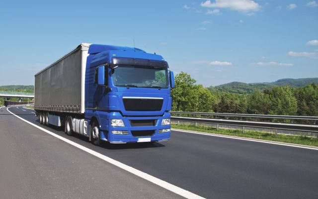 Blauer LKW auf der Autobahn (für Lieferung/Montage)