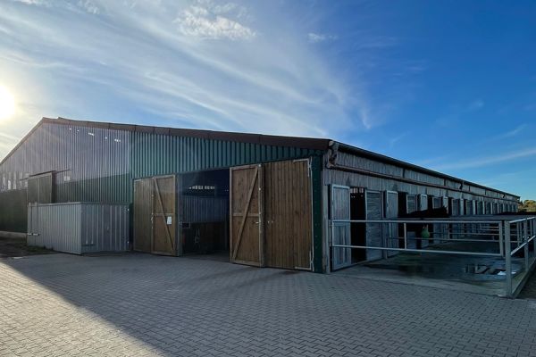 ußenansicht einer modernen landwirtschaftlichen Stallhalle in Holz- und Metallbauweise.