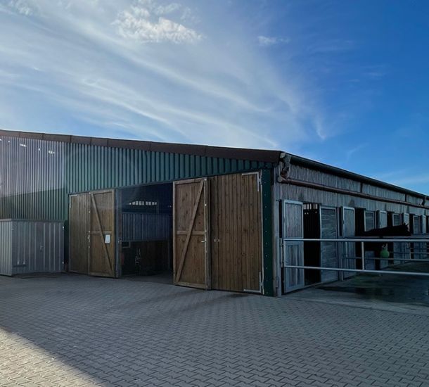 ußenansicht einer modernen landwirtschaftlichen Stallhalle in Holz- und Metallbauweise.